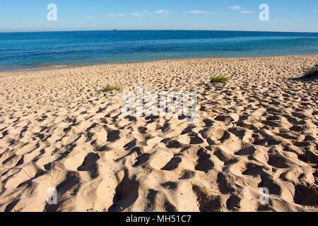 Vista panoramica delle impronte sulla spiaggia vicino a dune di sabbia in spiaggia del Faro in Bunbury Western Australia su una fine mattinata estiva creano modelli. Foto Stock