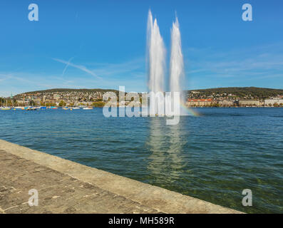 Una fontana e barche sul lago di Zurigo in Svizzera, gli edifici della città di Zurigo in background. La foto è stata presa all'inizio del Octob Foto Stock