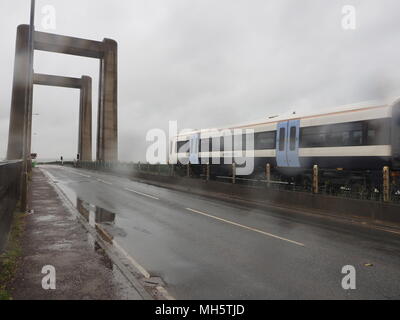 Isle of Sheppey, Kent, Regno Unito. Il 30 aprile, 2018. Regno Unito: Meteo acquazzoni pesanti e gale force venti combinato per fare terribili condizioni di guida e di trasporto sull'Isle of Sheppey in nord Kent oggi. Una folata di 55mph (tempesta forza 10) è già stato registrato a 7.30 dal circolo velico locale della stazione meteo. Il Pic: Kingsferry ponte che porta la principale linea ferroviaria per l'isola dal continente. Credito: James Bell/Alamy Live News Foto Stock