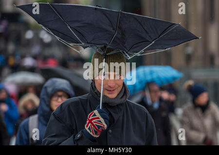 Londra, Regno Unito. Il 30 aprile 2018. La gente lotta con ombrelloni prima di attraversare il ponte Millenniium nel vento e pioggia. Credito: Guy Bell/Alamy Live News Foto Stock