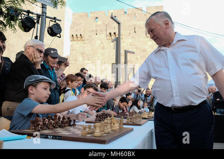 Gerusalemme, Israele. Il 30 aprile, 2018. ANATOLY KARPOV YEVGENYEVICH (R), 66, russo gran maestro di scacchi gioca a scacchi contro decine di giovani israeliani champions contemporaneamente presso la Porta di Jaffa nel quadro di Israele il settantesimo celebrazioni del Giorno dell'indipendenza. Credito: Nir Alon/Alamy Live News Foto Stock