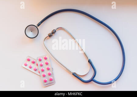 Stetoscopio medico o phonendoscope isolati su sfondo bianco e rosa medicina. Concetto di salute Foto Stock