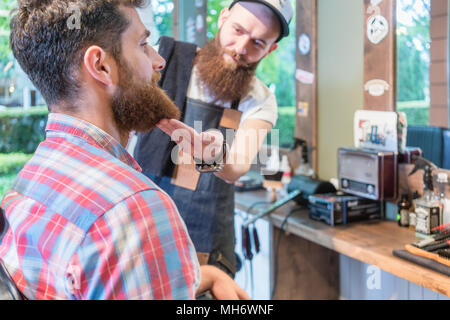 Close-up della testa di un redhead barbuto giovane uomo pronto per un taglio di capelli Foto Stock