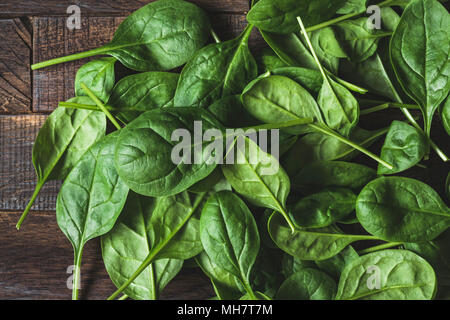 Baby Spinaci foglia sul legno come sfondo. Composizione orizzontale. Detox, uno stile di vita sano, mangiare sano, dieta vegana concept Foto Stock