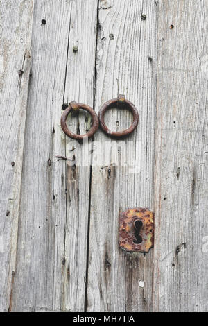 Vecchie porte in legno con maniglie in bronzo e toppa. Foto Stock