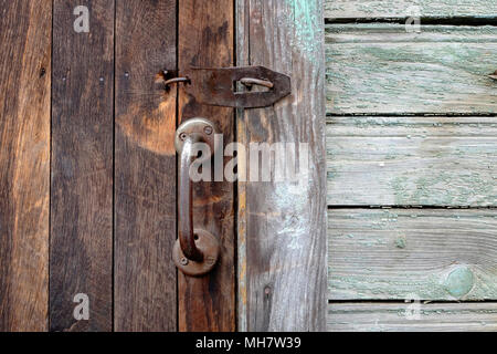 Vecchie porte in legno con maniglie in bronzo e toppa. Foto Stock