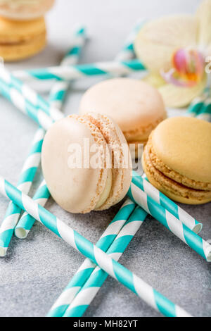 Assortiti francese macarons sulla luce di cemento grigio Sfondo. Vacanze concetto alimentare. Foto Stock