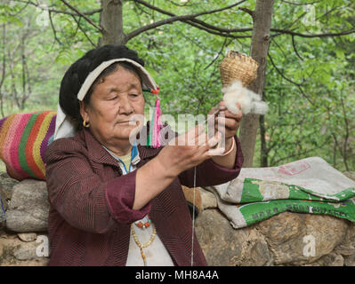Tibetana locale la filatura della lana nel villaggio di Jiaju, Sichuan, in Cina Foto Stock