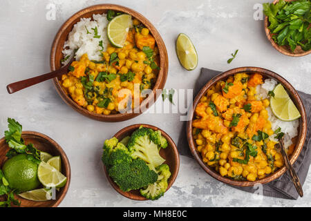 Vegane patata dolce curry di ceci in ciotola di legno su uno sfondo luminoso, vista dall'alto, cibo laici piana. Una sana alimentazione vegetariana concetto. Foto Stock