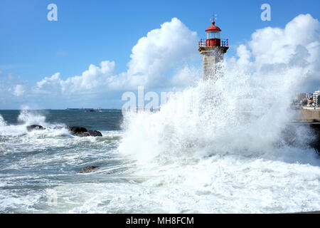 Tempesta onde di oltre faro e cielo blu a Porto, Portogallo Foto Stock