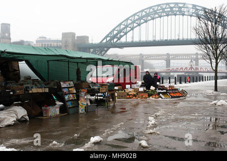 Gli operatori di mercato per la vendita di frutta e verdura su una banchina deserta su una neve Domenica mattina a Newcastle, Tyne and Wear, Regno Unito. Foto Stock