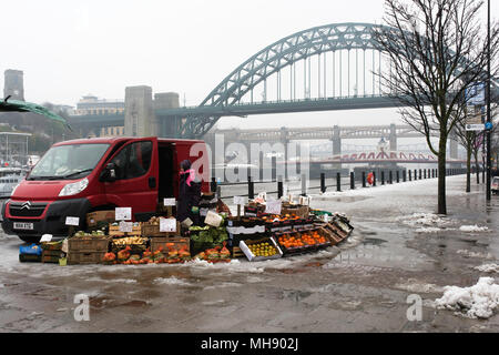 Gli operatori di mercato per la vendita di frutta e verdura su una banchina deserta su una neve Domenica mattina a Newcastle, Tyne and Wear, Regno Unito. Foto Stock