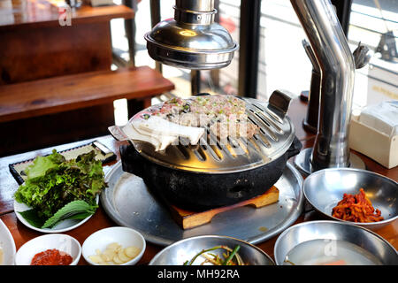 Coreano Tradizionale cucina: di carne con verdure sul fuoco tostatore Foto Stock