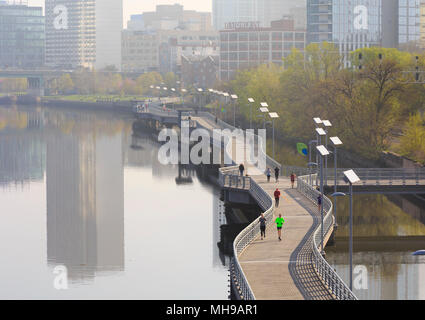 Lo Skyline di Philadelphia con Schuylkill River Park Boardwalk in primavera con gli amanti del jogging e il ciclista, Philadelphia, Pennsylvania, STATI UNITI D'AMERICA Foto Stock