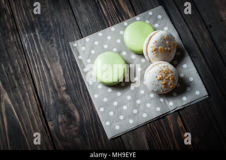 Colorati Macarons francese su scuro dello sfondo vwooden Foto Stock