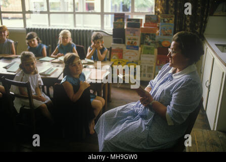 Scuola elementare del villaggio UK 1980s insegnante di scuola lettura a classe di bambini. Sapperton, Gloucestershire 1980. HOMER SYKES Foto Stock