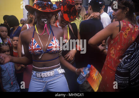 Notting Hill Carnival West London. La Gran Bretagna etnica. Giovane ragazza britannica nera che indossa un abbigliamento Union Jack, un reggiseno bikini che balla in strada con un fischio. HOMER SYKES anni '1990 Foto Stock