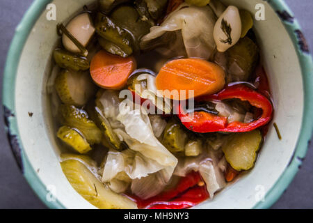 Mix di sottaceti turco con pomodori verdi, il peperone rosso, il cetriolo e la carota in una ciotola. Foto Stock