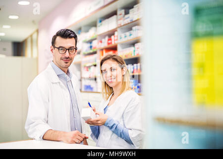 Due farmacisti lavorando in una farmacia. Foto Stock