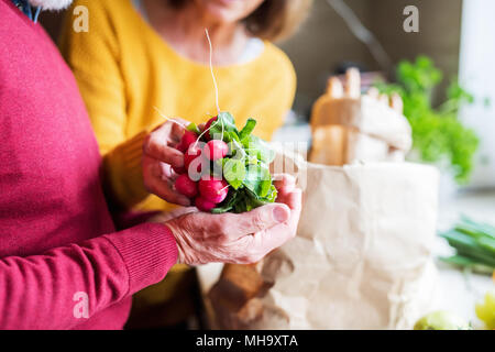 Coppia senior disimballaggio in cucina il cibo. Foto Stock