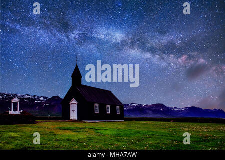 Vista Montagna Islanda. Fantastico cielo stellato e la via lattea. Nero bellissima chiesa di legno in Budir Foto Stock