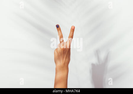 Bella Mano femmina con manicure su sfondo bianco in presenza di luce solare close-up Foto Stock