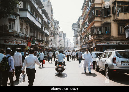 Una strada trafficata durante le ore di punta in Mumbai, India con un sacco di pedoni e scooter. Foto Stock