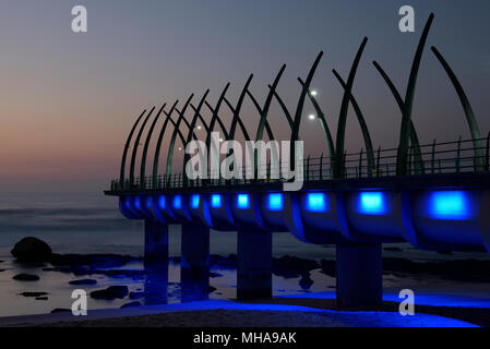 Durban, KwaZulu-Natal, Sud Africa, fila di luci blu su iconico punto di riferimento pier di Umhlanga Rocks Beach, dawn, paesaggio Foto Stock