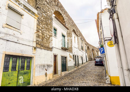 Evora street con le tradizionali case costruite in antico acquedotto romano, Alentejo, Portogallo Foto Stock