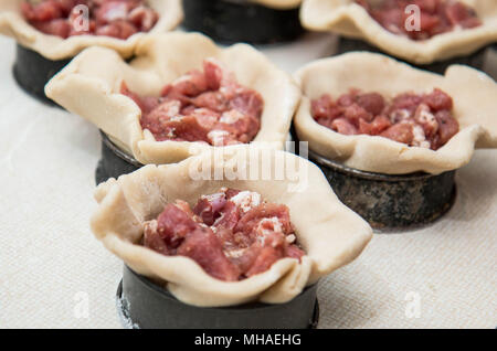 Realizzazione artigianale pasticci di carne di maiale Foto Stock