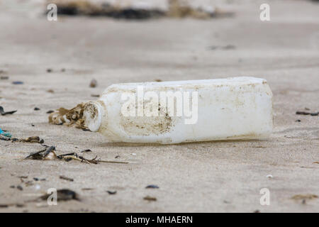 Latte in plastica bottiglia lavato fino ad una spiaggia di sabbia Un esempio dei molti pezzi di immondizia in mare in tutto il Regno Unito Foto Stock