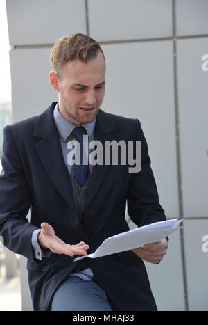 Imprenditore emotivamente la lettura dei documenti Foto Stock