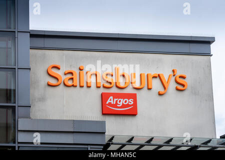 Un arancione Sainsbury's e segno rosso - i due esercizi commerciali si sono fuse nel 2016 Foto Stock