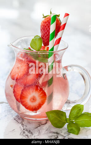 Limonata fatta in casa con fragole fresche e basilico su ghiaccio Foto Stock