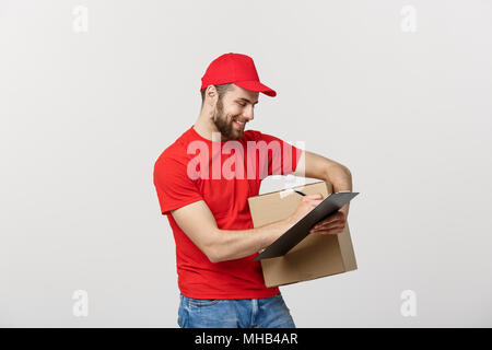 Ritratto di sorridente consegna maschio uomo sulla scrittura di appunti e la scatola di contenimento. Isolato su sfondo bianco Foto Stock