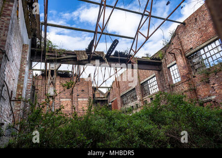 Old industrial brick warehouse con esposte le travi del tetto. Foto Stock