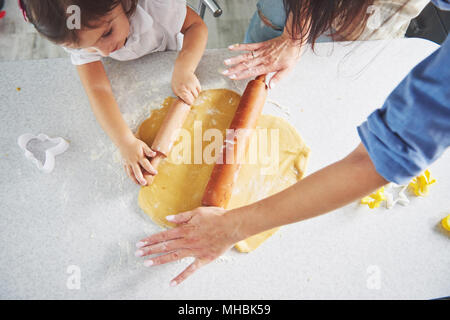 La famiglia felice vacanza preparazione del concetto di cibo. Cucina di famiglia biscotti di Natale. Le mani della madre e figlia preparare la pasta sul tavolo. La famiglia felice nel rendere i cookie a casa Foto Stock