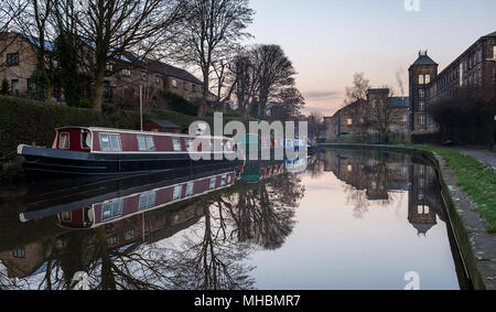 Barche strette e riflessi nella pittoresca cittadina di Skipton, Inghilterra. Foto Stock