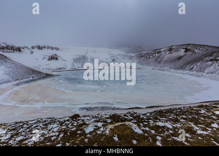 Lago ghiacciato nel cratere di viti in Krafla area geotermale nei pressi del Lago Myvatn, Nord Islanda Foto Stock