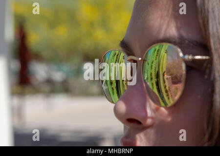 Ragazza giovane con occhiali da sole riflettenti Foto Stock