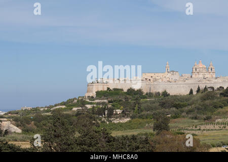 Antica collina fortificata città capitale di Malta, la città silenziosa, Mdina o L-Imdina, skyline contro la molla blu cielo con enormi pareti, cupola della cattedrale Foto Stock