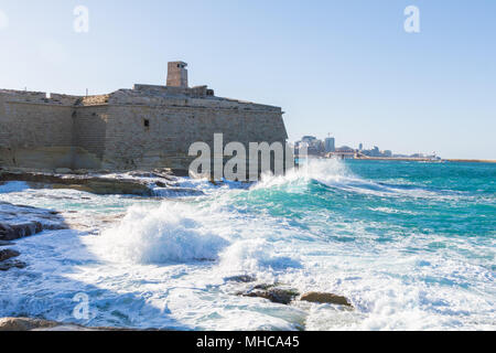 Onde infrangersi contro Fort Ricasoli Foto Stock