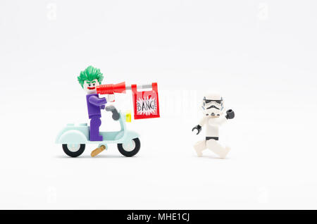 La mini figura di joker scooter di equitazione con pistola bang a caccia di Storm Trooper. Lego minifigures sono fabbricati da Lego. Foto Stock