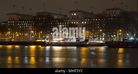 Vista notturna del Tamigi, a Londra con un party in barca e MOD (Ministero della Difesa) edificio, mostrando RAF memorial Foto Stock