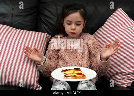 6 anno vecchia ragazza con il formaggio su pane tostato Foto Stock