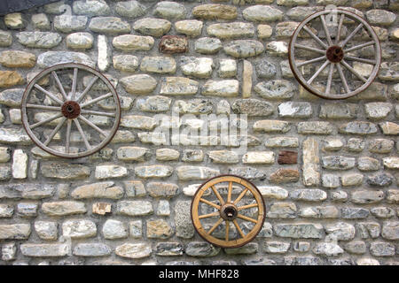 Far West ruota di carro isolato sulla parete Foto Stock