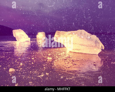 Effetto astratto. Vista in dettaglio in un ghiaccio con graffi profondi e crepe. Tagliare floe contro al cielo di sera e la luce spot. Foto Stock