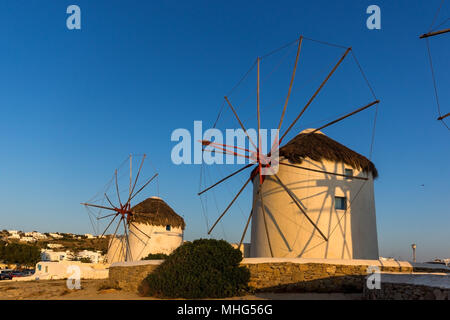 Gli ultimi raggi di sole su bianco mulini sull'isola di Mykonos cicladi grecia Foto Stock