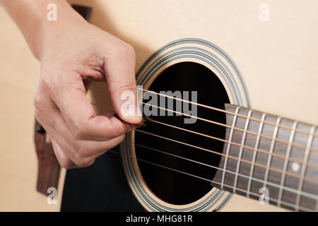 Vicino la donna con le mani in mano suonare la chitarra acustica. Foto Stock