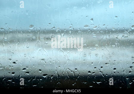 Gocce di pioggia sulla finestra di vetro che guarda verso seascape, North Norfolk, Inghilterra Foto Stock